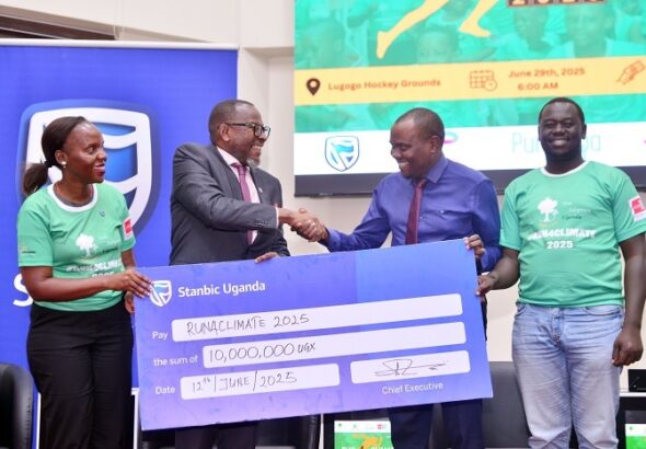 Baziwe Alan, the Stanbic Vice President Public sector handing over the dummy Cheque to Issa Katwesigye, Ast Commissioner for Forestry in the Mi