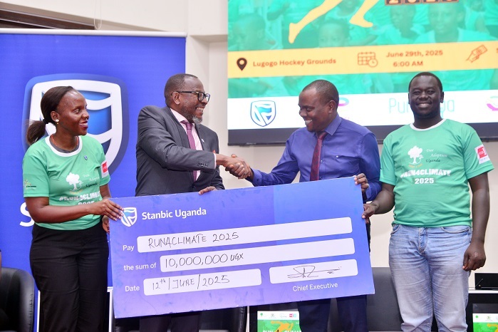 Baziwe Alan, the Stanbic Vice President Public sector handing over the dummy Cheque to Issa Katwesigye, Ast Commissioner for Forestry in the Mi