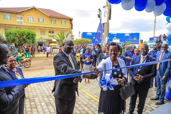 Richard Rwabuhinga, LC V Chairman for Fort Portal Tourism City and Guest of Honour cuts the ribbon as he officially launches the dfcu Bank Fort