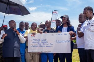 Fred Bwino Kyakulaga the State Minister of Agriculture, Animal Industry and Fisheries presents a dummy cheque of UGX 1.2b with Equity Bank’s Director of Public Sector And Social Investment Catherine P