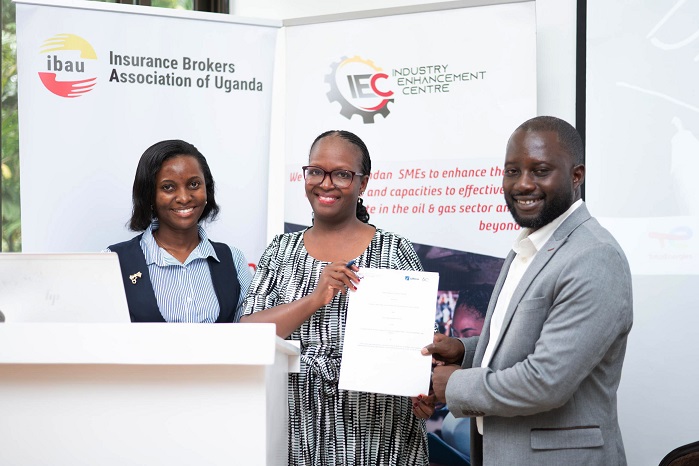 Annette Kiconco, dfcu Bank Chief Retail Banking Officer (c) holds a signed Memo with IEC Executives