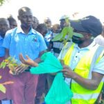 Denis Emmanuel Oweka- ECOTRUST's regional project coordinator training students on how to use aqua soil during the tree planting session 01